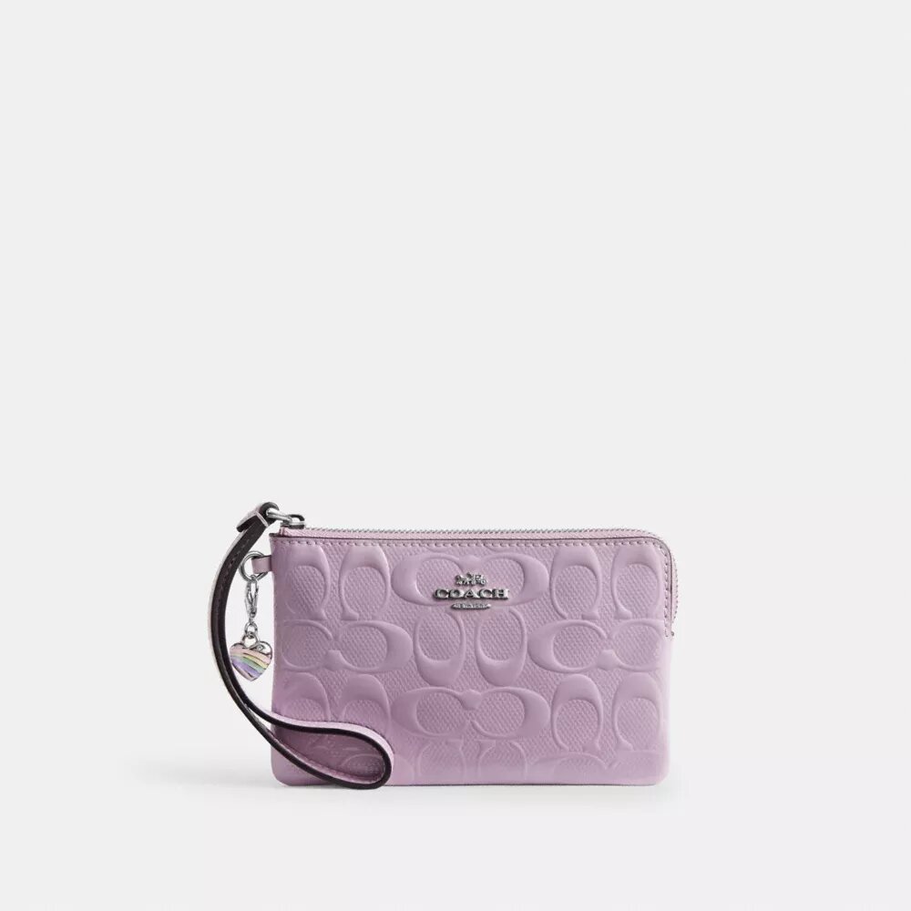 Saszetka na nadgarstek z zamkiem w rogu, wykonana z charakterystycznej skóry z zawieszką w kształcie serca